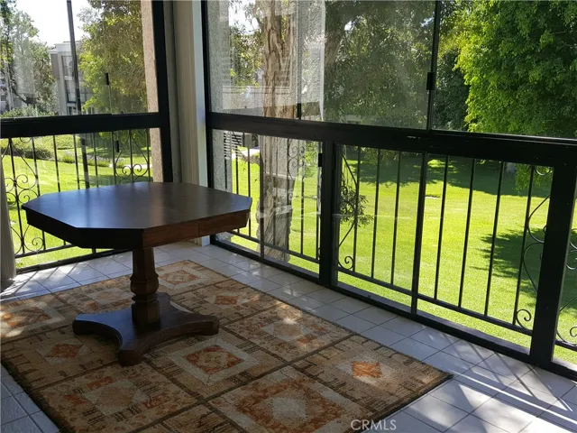 What a nice setting! Glass enclosed balcony allows you to have extra space in quiet backyard with trees and glasses.