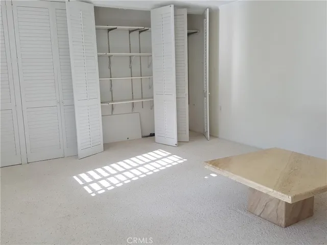 Living room with built-in closet with shelves.