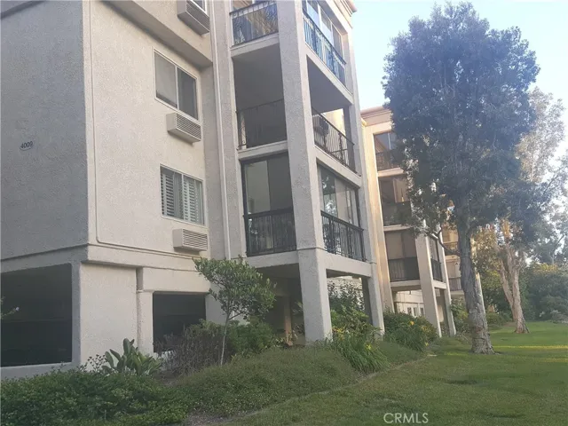 Building rear view of the end unit with glass enclosed balcony.