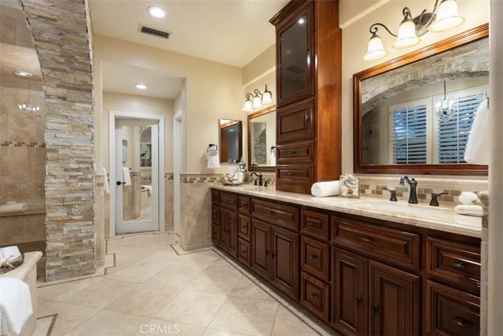 Another view of the luxury dual vanities, marble counters and custom designed backsplash.