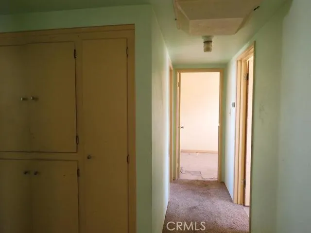 From living room, looking down the hall.  Hall bath is to the left of the cabinets.  Also to the left is an area for a washing machine.