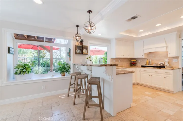 Kitchen with breakfast bar and a view of the backyard.