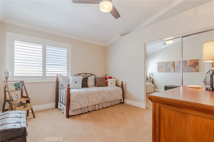 Guest bedroom located upstairs with ceiling fan and plantation shutters.
