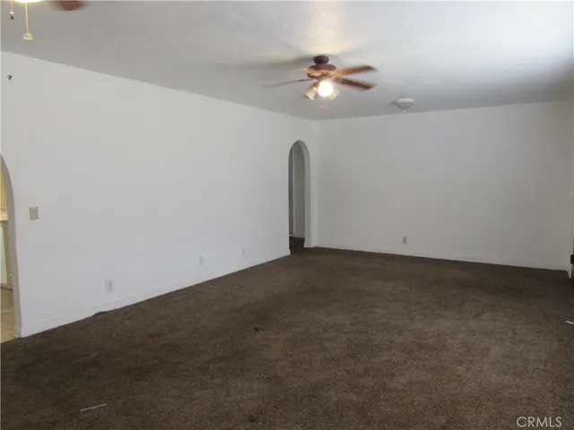 Living room has two archways. One to kitchen and one to the hallway leading to two of the bedrooms.