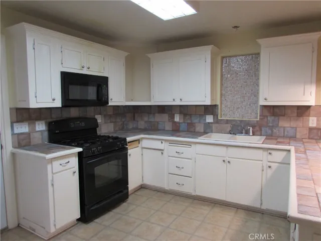 Kitchen offers, tiled counter tops, gas stove and microhood