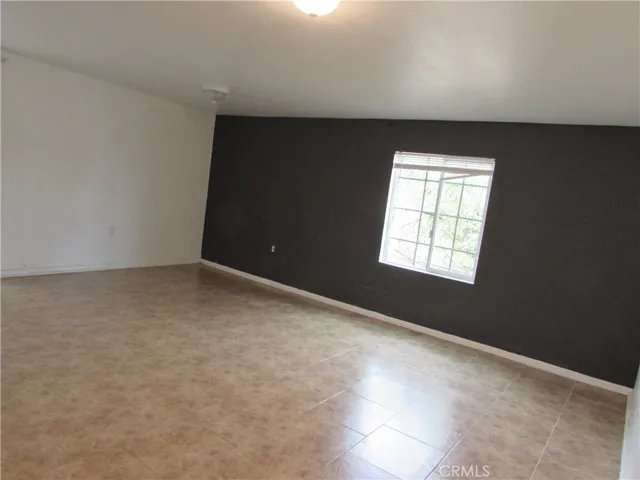 Spacious bonus room in the back of the home with tiled flooring.