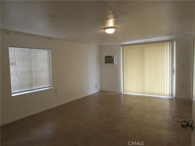 Master bedroom has tiled flooring and slider leading to the back of the home