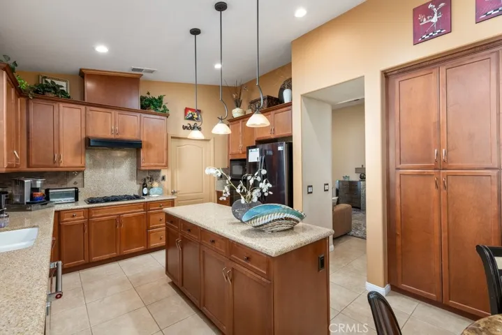 Kitchen with upgraded cabinets with pull outs and hardware and also good-size island - walk-through door in middle to indoor laundry
