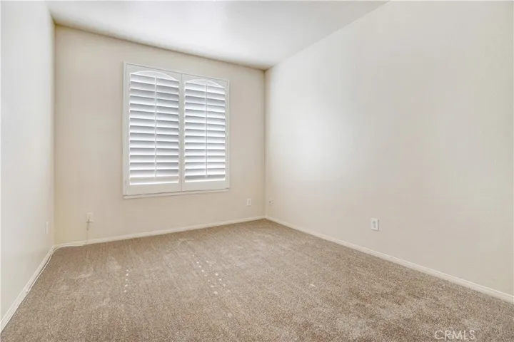 Bedroom 2 is carpeted with plantation shutters.