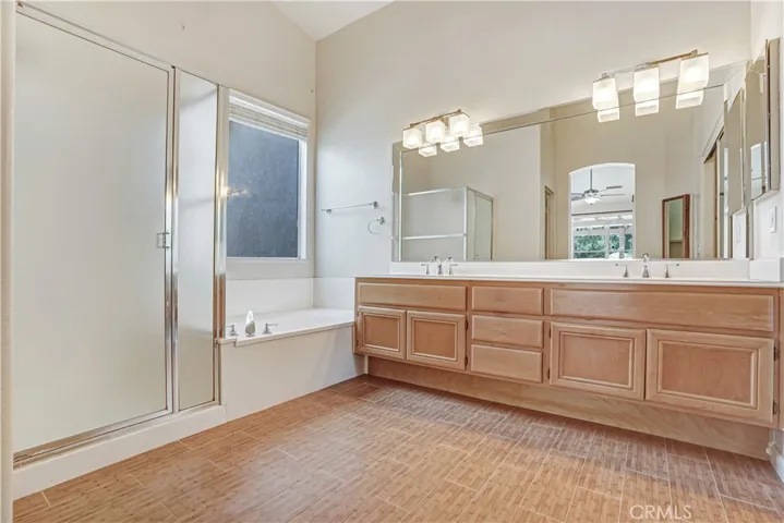 Master bath with decorative lighting, dual sinks and separate tub and shower