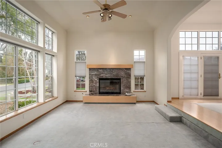 Another view of living room with picture windows and fireplace