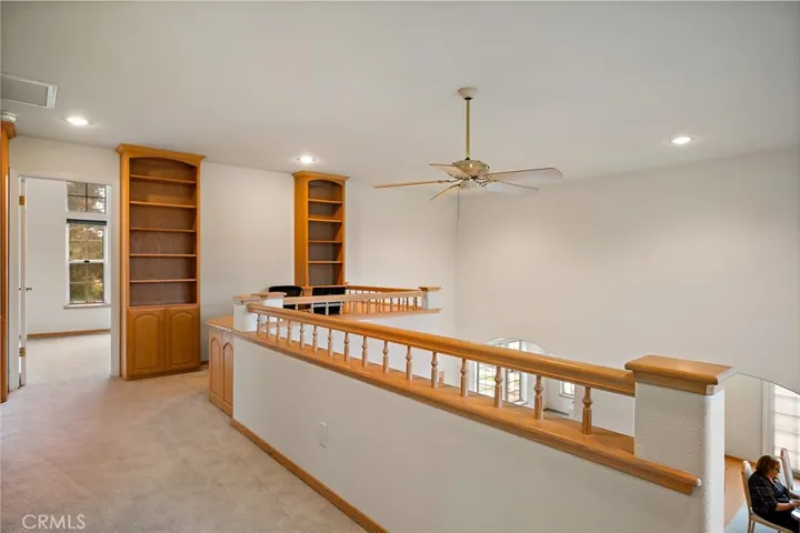 Upstairs landing with built it bookcases, cabinets and desk