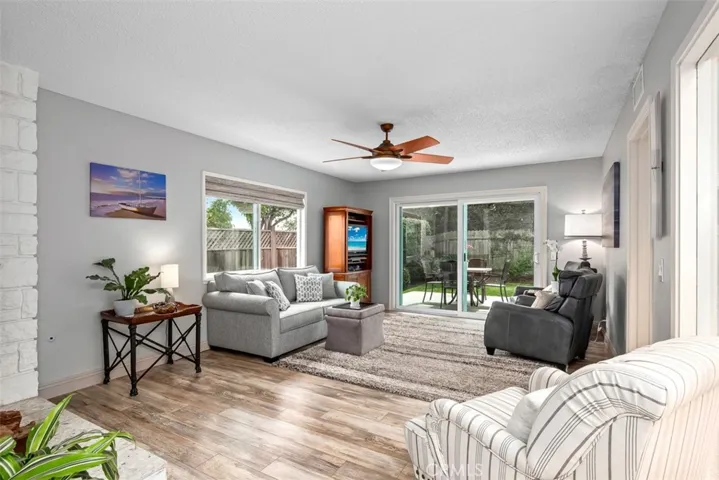 New flooring is contiguous through out the home. The living room is large enough for a piano or larger furniture if desired. Slider at back brings summer breezes in and a wonderful fireplace on the left bring a coziness on cool days.