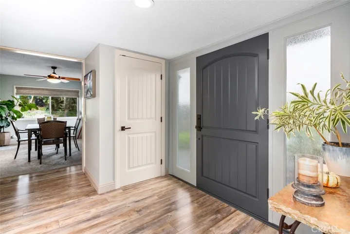 Looking towards the dining room, a large coat closet in the Foyer is backed to a Dry Bar with shelving in the dining room.
