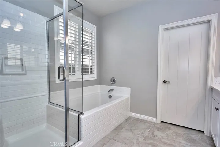 Master Bath offers a large soaking tub, plantation shutters & glass enclosed shower, and large walk in closet