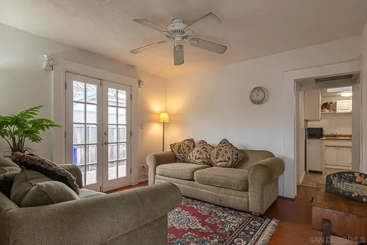 12x12 Living, with double doors to private patio, ceiling fan and wall heater.