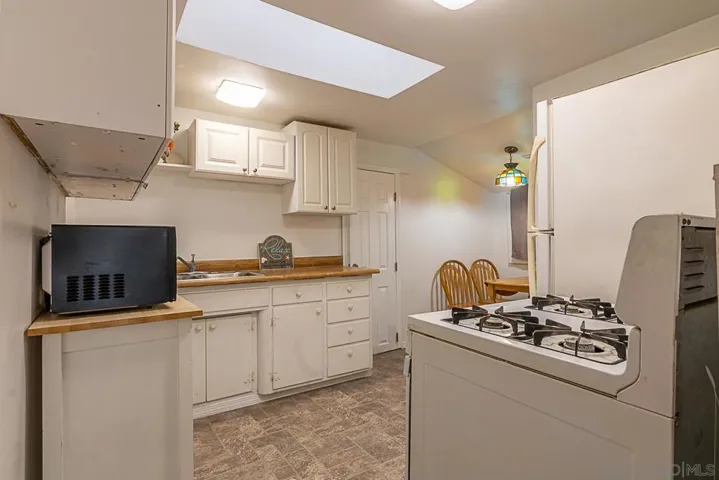 Full size kitchen with gas stove/oven, dining area, and the door leads to the studio.