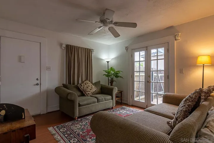12x12 living area with ceiling fan and doors to the patio.