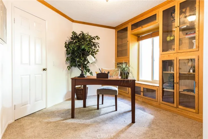 Staged office with crown molding and built in cabinets.