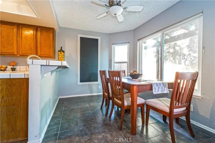 Kitchen with ceiling fan, ceramic tile floors, breakfast bar and nook overlooking the backyard.