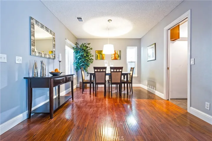 Staged dining room with wide baseboards and attractive wood laminate flooring.