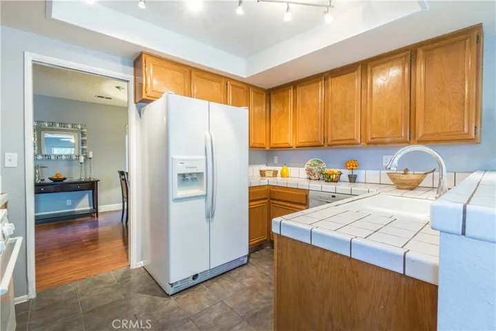 Kitchen with tile counters and ceramic tile floors with adjoining door to the dining room.