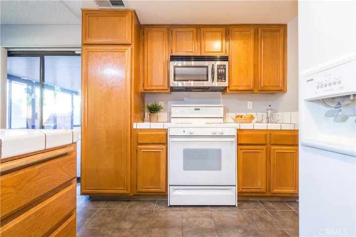 Kitchen with gas range, oven, and microwave.