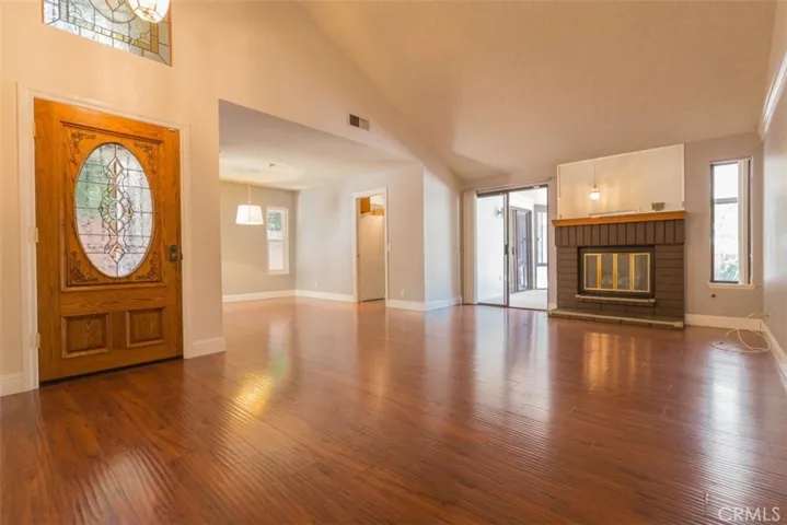Spacious family room with gorgeous front door and wood laminate flooring.