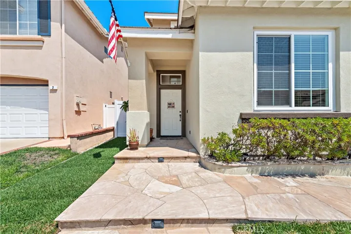 The lovely entry is accented with planters and custom stone hardscape.