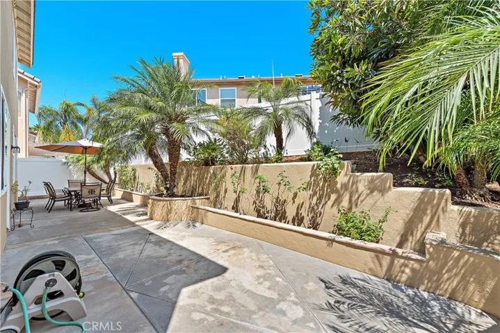 The lovely backyard is accented with palms and gardens and has an open feel to enjoy the gorgeous SoCal weather.