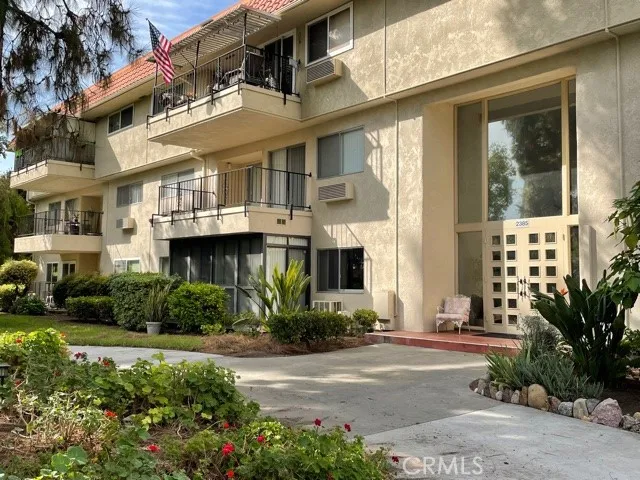 Exterior of building, condo is to left of front door, ground floor with enclosed patio.