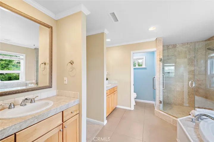 master bath with dual sinks and tub & walk in shower