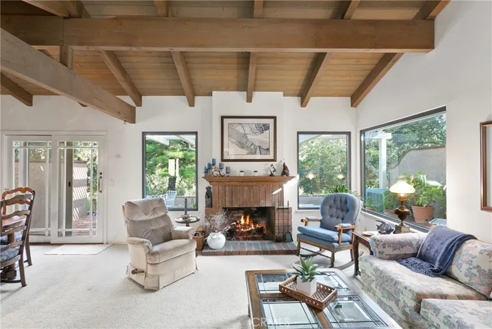 Enter to Family room with views out the custom picture windows. Note the high wood & beamed ceilings.