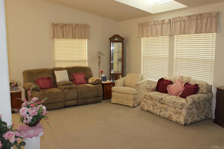 View of living room showing high vaulted ceiling and skylight.
