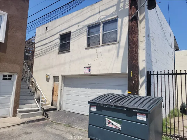 Rear view of residential unit and garage