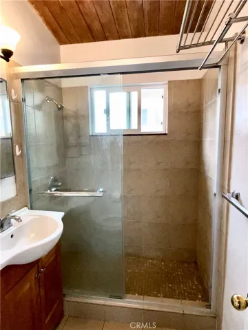 Walk in shower bathroom w/ high wooden plank ceilings