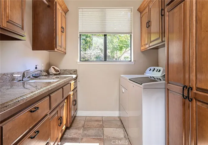 Laundry Room with cabinetry and sink just off the garage