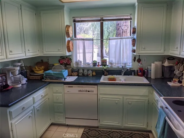 Kitchen full view . Cast iron double sink, garbage disposal. Electric cook top range, Dish washer, Window over the sink facing parking area.