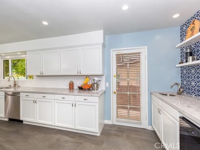 Kitchen showing wet bar and wine refrigerator, geometric tile backsplash