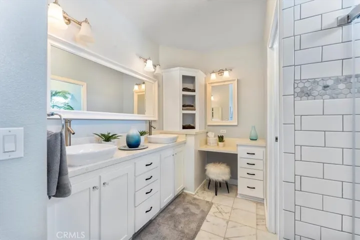Stylish white subway tiles and on the corner a small vanity