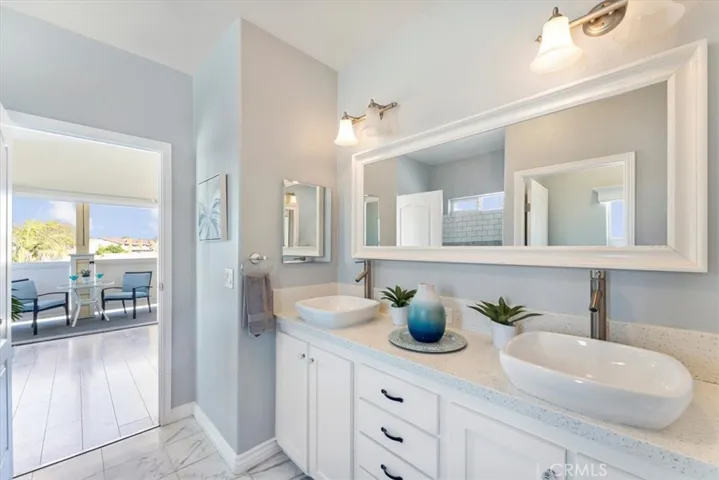 Master bathroom with dual sinks, quartz counters,and stone floors