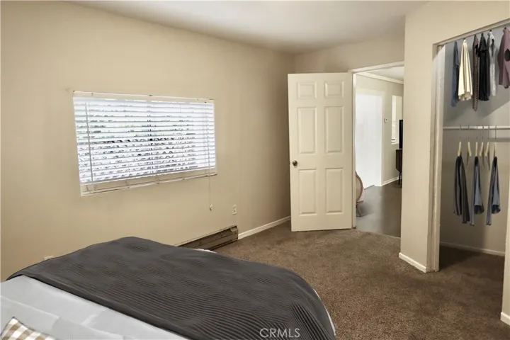 Another view of the bedroom that shows the walk-in closet with built-in.