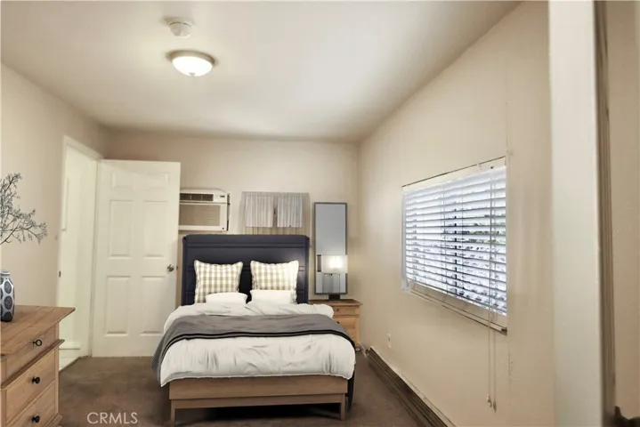 Bedroom with wall AC, and bath to the left.