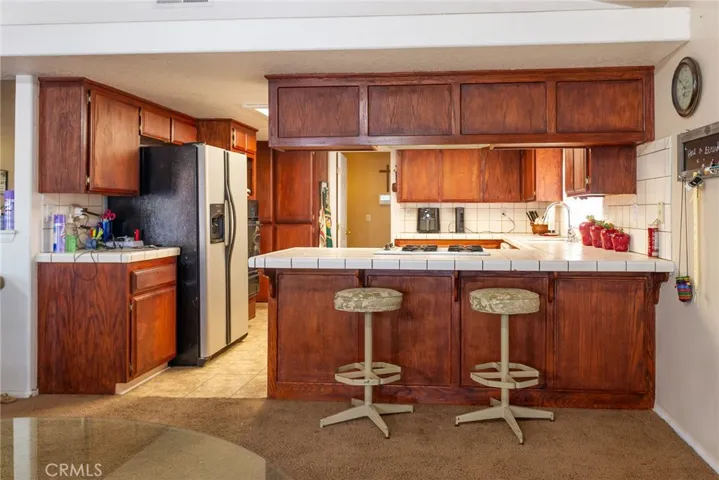 Breakfast bar to kitchen from casual dining area adjacent to living room