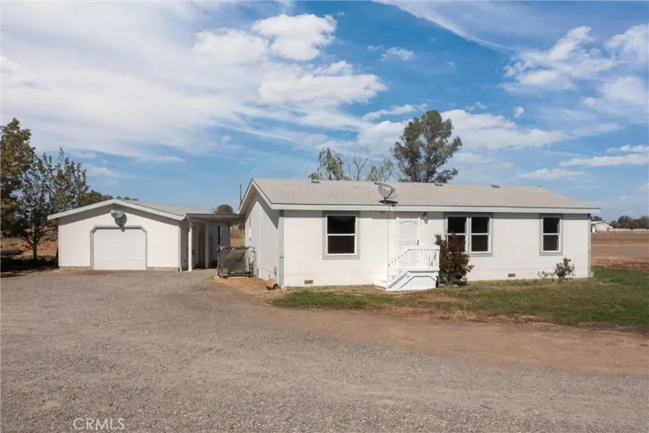Front of the house with detached single car garage with workshop space inside