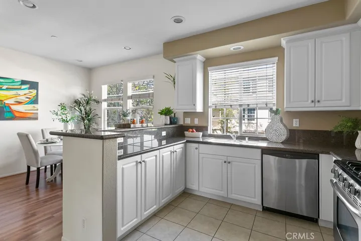 White cabinetry and granite counters are featured in the kitchen along with stainless steel applicances.