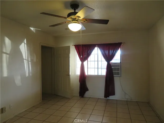 En-suite bedroom with window A/C and fan