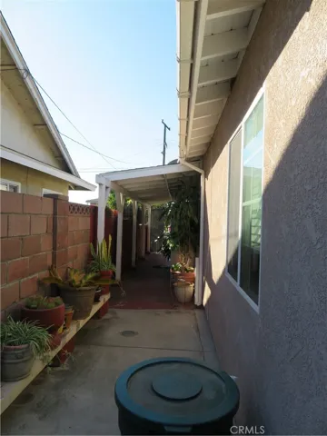 Opposite side of walkway from backyard to front of home and side door entry to kitchen area