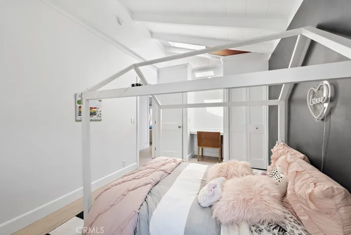 Guest bedroom with sky light, built in desk, and ample closet space.