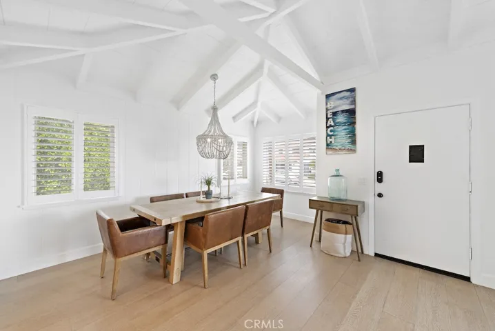 Dining room with gorgeous beamed ceilings and new white shutters.